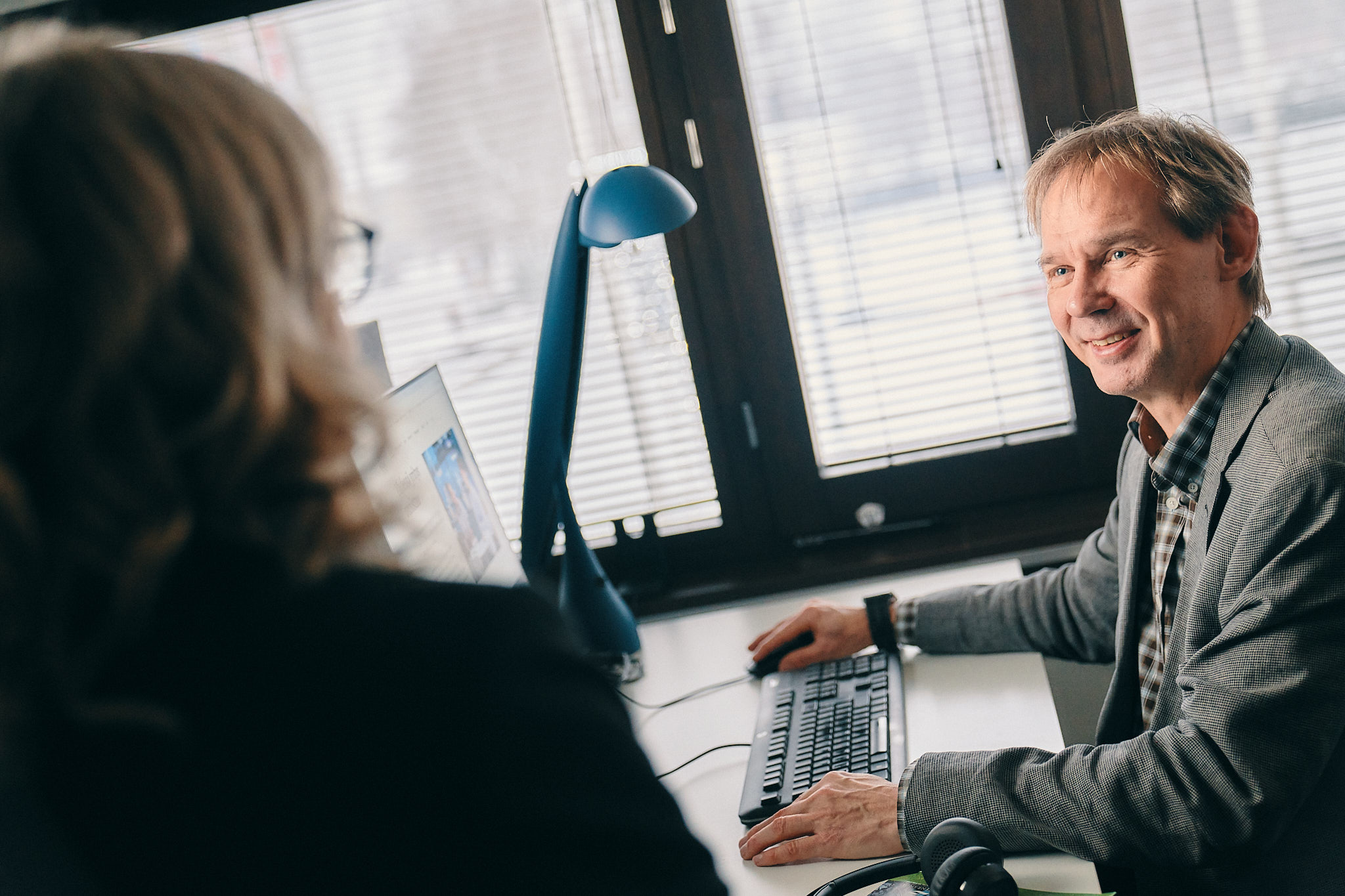 Kaksi henkilöä työhuoneessa iloisena.